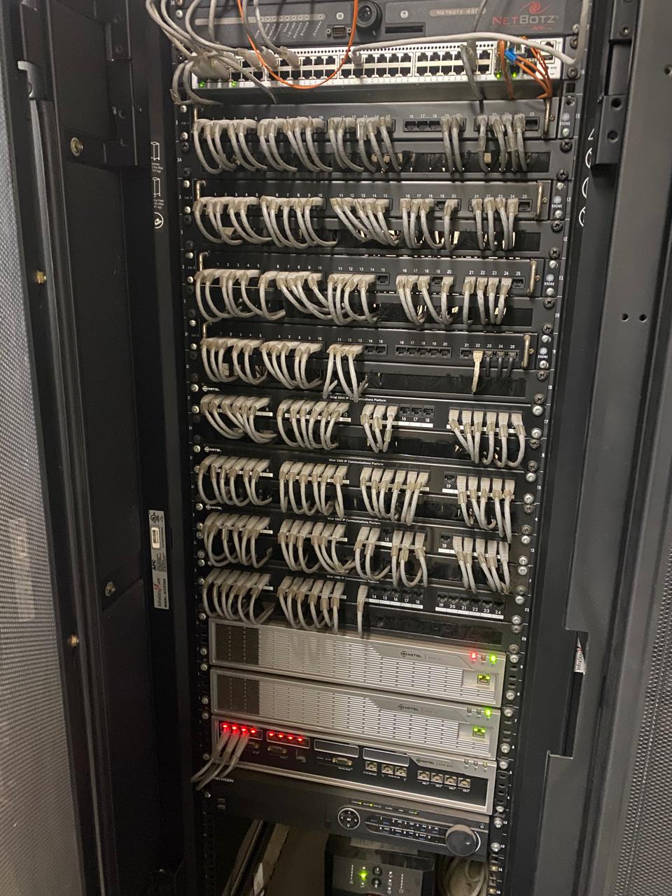 Floor-to-ceiling server cabinet with patch panels and structured cabling